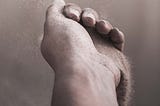 A hand with dry sand falling freely