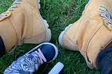 Image of mommy’s boots and baby shoes.