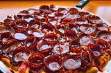 A pizza covered in Old World style pepperoni that cups and chars when baking.