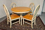 A round wooden dining table with four matching chairs