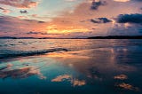 Warm redish glow in the clouds over the ocean at sunset