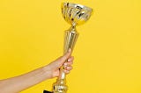 A person holding a trophy with one hand