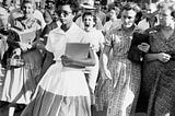 Elizabeth Eckford walks into Little Rock High in 1957 while white students taunt her