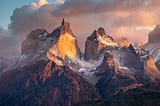 “Sunrise” An epic view of Torres del Paine. In the early morning, when conditions are just right, the first sunlight beautifully highlights parts of the mountains.