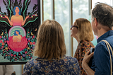 A woman and a man admiring a painting at an exhibition at Daftarkhwan | Downtown.