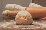 Bread dough on a floured surface; rolling pin