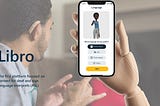 A hand holding a phone with a screen app to select your language.