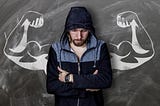 Man looking down with arms folded against a backdrop of fake muscular arms