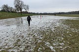 Walker skating on frozen floodwater in a field from the River Avon in Keynsham