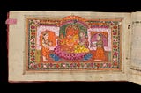 A photographic digitised image showing an illustrated page inside a manuscript from Wellcome Collection (Wellcome MS Indic Alpha 978). The brightly coloured illustration shows two people with a Hindu deity, there is an intricate border of flowers around the figures.