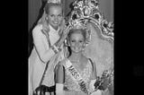 Miss America 1970, Pamela Eldred, sits on her throne to receive her new crown.
