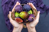 Closeup shot of a person holding fresh figs