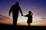 The shadow images of a father holding the hand of his daughter against the backdrop of a sunset.