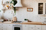 A light airy kitchen, with white brick walls and white cabinets.