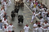 Bulls and people are running in Santo Domingo Street during San Fermin festival, Pamplona