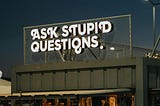 A fairground sign that reads Ask Stupid Questions