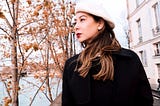 Portrait of author in Paris, wearing a beret, and looking out towards the Seine.