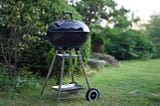 A Weber BBQ sitting in a driveway.