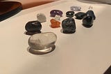 An assortment of colourful crystal gemstones laid out on a white surface.