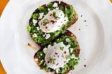 Mashed sweet peas on toast with poached eggs on top.