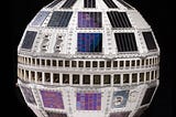 Color photo against black background of Telstar satellite