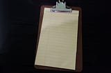 Clipboard with blank yellow legal pad attached.