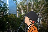Cartoon shape in the middle of a park. Behind the park is a glass office looking building. The cartoon is wearing a black hat, whtie shirt and orange cardigan.