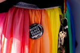 Close up of the rainbow skirt of a Gay Pride participant. A pin on the skirt reads “Protect Black Trans Women.”