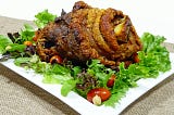 A crispy roast leg, served on a bed of salad.