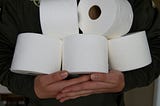 Person holding a stack toilet paper