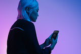 A woman holding a cell phone with Dark Mode enabled.