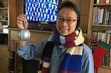 Photo of author showing off his Christmas gifts of a Poke Ball, Dr. Who scarf and ear muffs.