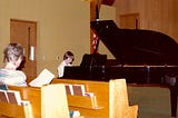 Piano teacher Mrs. Kiffmeyer instructing Gentry Bronson just prior to a piano performance