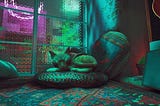 A small orange cat curled up on a pillow. A blue neon light illuminates the room.