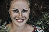 Portrait of young woman, smiling. freckles.