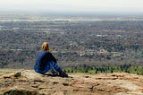 girl is seating on a mountain