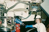Sheila Crosby in protective clothing filling an astronomical camera with liquid nitrogen