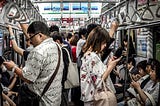 Everybody checking their phone on a local train.