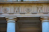 A frieze with Tuscan columns, flowers and brucaniums