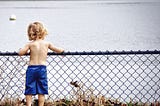 A little boy looking at the lake