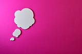 White thought bubble on pink background