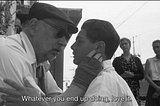 Black and white screenshot from the film: Cinema Paradiso directed by Giuseppe Tornatore. An older man holds a young boy’s face. The subtitle reads: whatever you end up doing, love it.