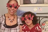 Mother and daughter wearing festive, glitter-crusted 2018 sunglasses for New Year’s Eve.