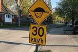 happy face drawn on speed bump sign