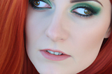 A close-up photo of a beautiful red-headed woman with  hazel eyes. Her eyes are crossed  but look outward far to the left and far to the right.