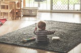 Baby learning about music by playing with a tambourine and a xylophone