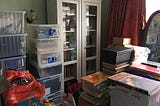 My father’s bedroom — bookcase, lots of plastic storage boxes and bags.