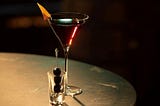 An enticing image of a Manhattan cocktail in an elegant glass with an orange twist and 3 cherries