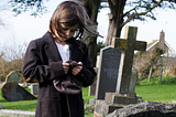 child at grave in cemetery