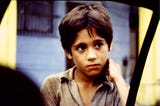 Photo of a young Cuban boy gazing into a window of a car as we stopped